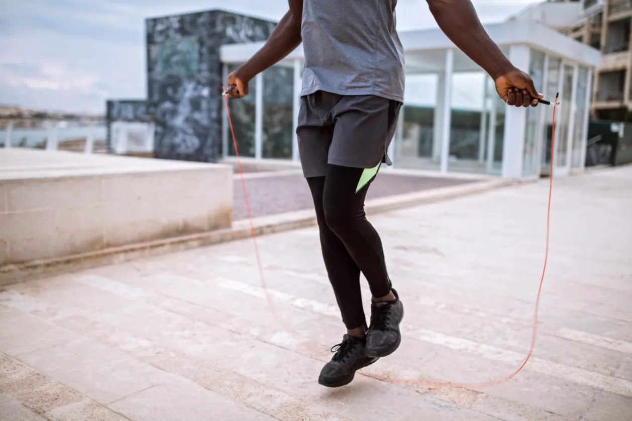 man jumping rope outdoors to manage stress